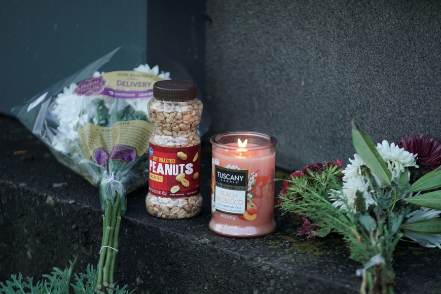 Flowers, peanuts and a candle lie by The Carter Presidential Center's sign, after the death of former U.S. President Jimmy Carter at the age of 100, in Atlanta, Georgia, U.S., December 29, 2024. REUTERS/Elijah Nouvelage