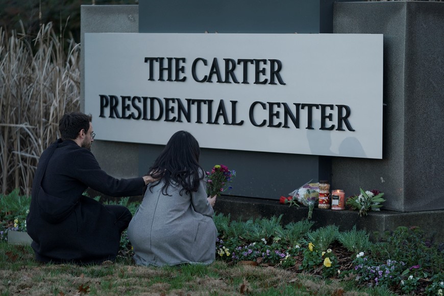 A woman holds flowers in front of The Carter Presidential Center's sign, after the death of former U.S. President Jimmy Carter at the age of 100, in Atlanta, Georgia, U.S., December 29, 2024. REUTERS/Elijah Nouvelage