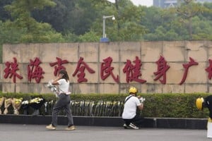 Personas dejando flores afuera del centro deportivo donde ocurrió el hecho, en Zhuhai, provincia de Guangdong, China, el 12 de noviembre de 2024