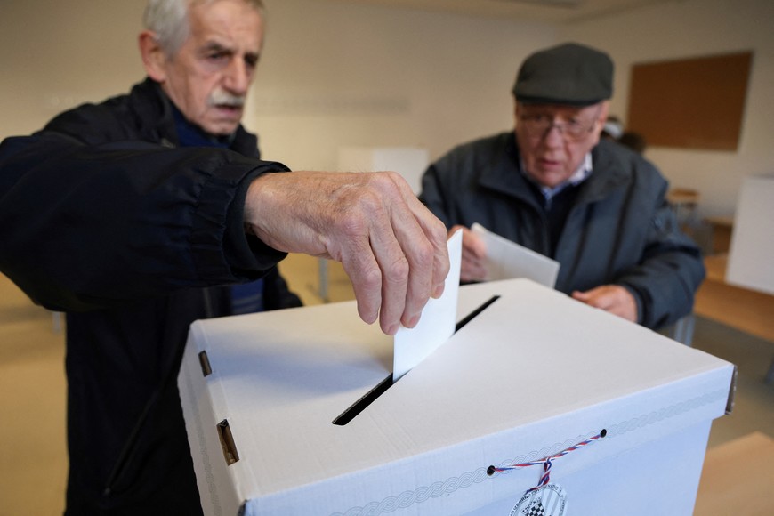 People vote at a polling station during the presidential election in Zagreb, Croatia, December 29, 2024. REUTERS/Djordje Kojadinovic