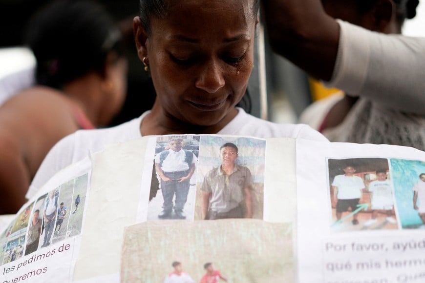 A relative holds a sign after Ecuador attorney general's office says four bodies found last week confirmed as missing boys of four minors, as it will seek charges against 16 military personnel over their suspected involvement, in Guayaquil, Ecuador December 31, 2024. REUTERS/Santiago Arcos