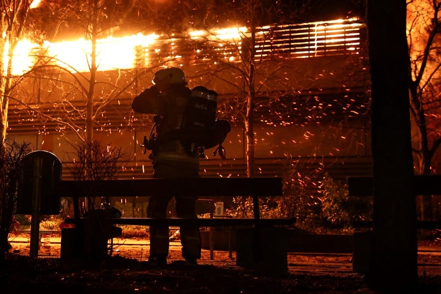 A Firefighter readies to extinguish a fire in a parking garage on New Year's Day in Berlin, Germany, January 1, 2025. REUTERS/Christian Mang     TPX IMAGES OF THE DAY