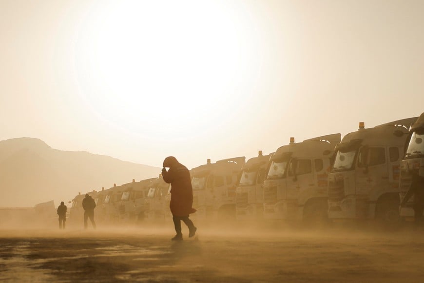 Rallying - Dakar Rally - Previews - Bisha, Saudi Arabia - January 2, 2025
People walk past trucks amid a sandstorm ahead of the Dakar Rally REUTERS/Maxim Shemetov     TPX IMAGES OF THE DAY