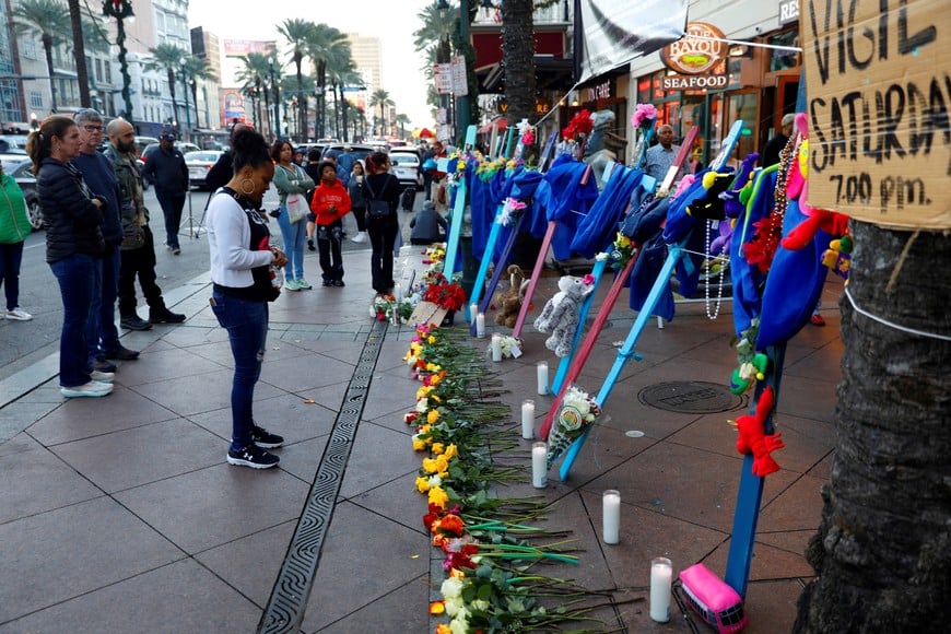 People pay their respects at a makeshift memorial where wooden crosses bearing the photos of victims who were killed are placed, two days after a U.S. Army veteran drove his truck into the crowded French Quarter on New Year's Day, in New Orleans, Louisiana, U.S. January 3, 2025. REUTERS/Octavio Jones