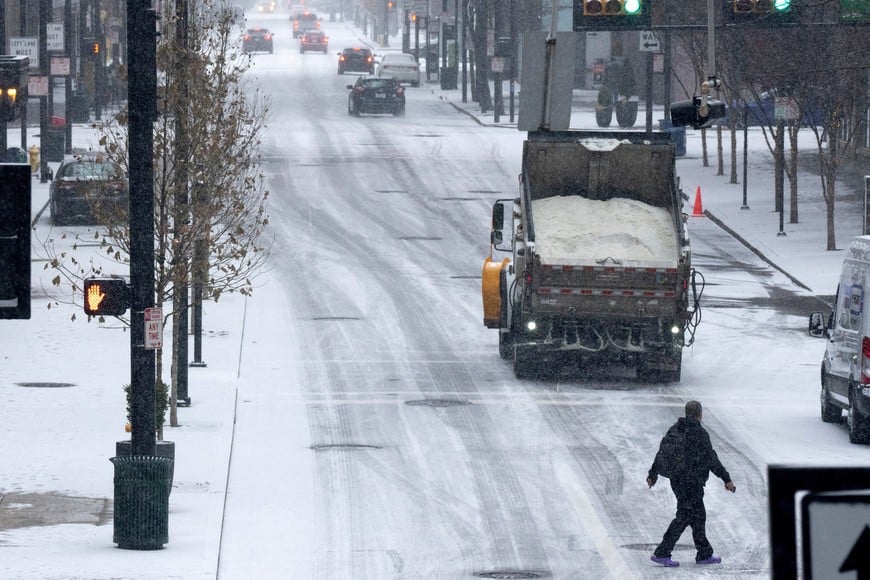 A salt truck drives downtown during a snow storm in Cincinnati, Ohio, U.S. January 5, 2025.  Albert Cesare/USA Today Network via REUTERS.   NO RESALES. NO ARCHIVES. MANDATORY CREDIT