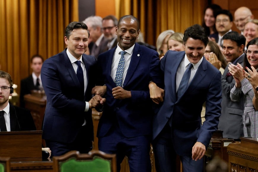 Newly elected Speaker Greg Fergus pretends to resist while being walked through the House of Commons by Canada's Prime Minister Justin Trudeau and Conservative Party of Canada leader Pierre Poilievre on Parliament Hill in Ottawa, Ontario, Canada October 3, 2023. REUTERS/Blair Gable     TPX IMAGES OF THE DAY