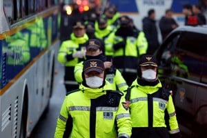 Agentes de policía caminan cerca de la residencia del presidente surcoreano destituido, Yoon Suk Yeol. Crédito: Reuters/Tyrone Siu. 