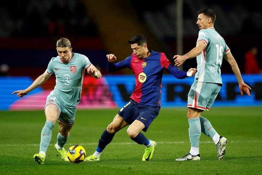 Soccer Football - LaLiga - FC Barcelona v Atletico Madrid - Estadi Olimpic Lluis Companys, Barcelona, Spain - December 21, 2024
FC Barcelona's Robert Lewandowski in action with Atletico Madrid's Conor Gallagher and Clement Lenglet REUTERS/Albert Gea