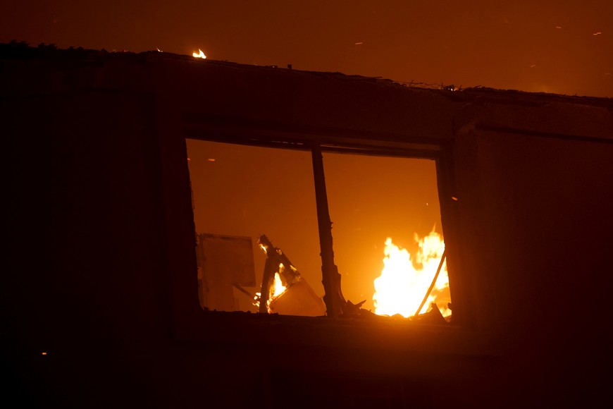 Flames rise in a building as the Eaton Fire burns in Pasadena, California, U.S. January 8, 2025. REUTERS/Mario Anzuoni