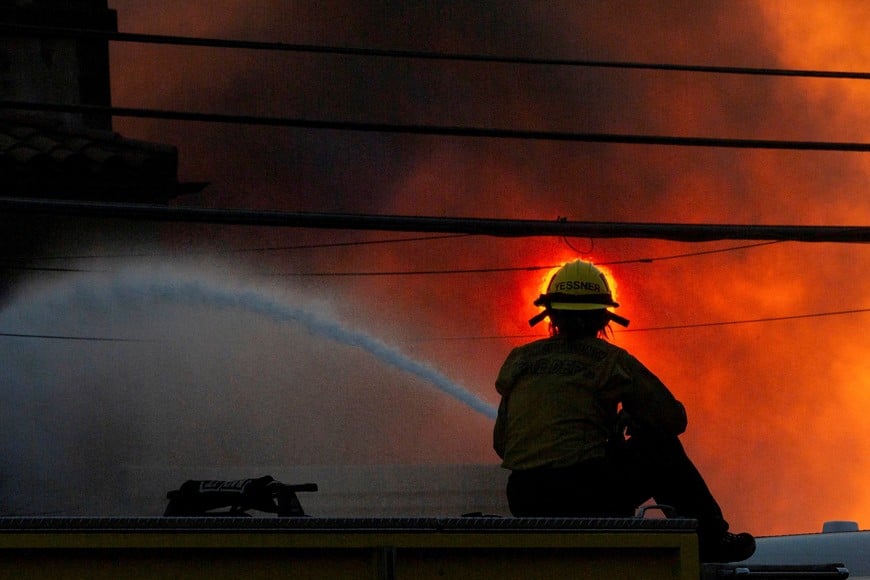 A firefighter battles the Palisades Fire as it burns during a windstorm on the west side of Los Angeles, California, U.S. January 8, 2025. REUTERS/Ringo Chiu     TPX IMAGES OF THE DAY