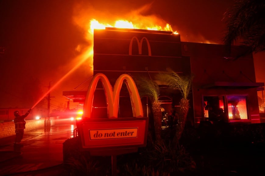 Firefighters work to extinguish flames as the Eaton Fire burns in Pasadena, California, U.S. January 7, 2025. REUTERS/Mario Anzuoni      TPX IMAGES OF THE DAY