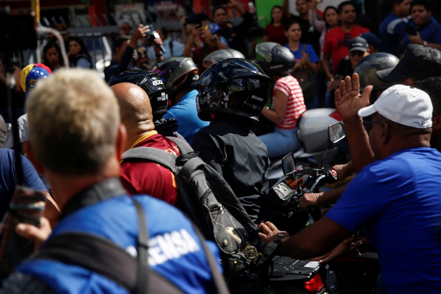 Venezuelan opposition leader Maria Corina Machado (wearing a black helmet) rides in the back of a motorcycle while protected by supporters as she leaves a protest ahead of the Friday inauguration of President Nicolas Maduro for his third term, in Caracas, Venezuela January 9, 2025. REUTERS/Leonardo Fernandez Viloria