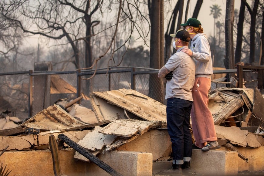 People return to the home after it has been burned down by wildfires in the Los Angeles area, at the Eaton Fire in Altadena, California, U.S. January 9, 2025. REUTERS/Ringo Chiu