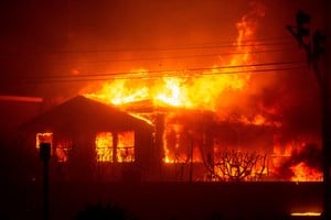 FILE PHOTO: Fire engulfs a structure as the Palisades Fire burns during a windstorm on the west side of Los Angeles, California, U.S. January 7, 2025. REUTERS/Ringo Chiu/File Photo