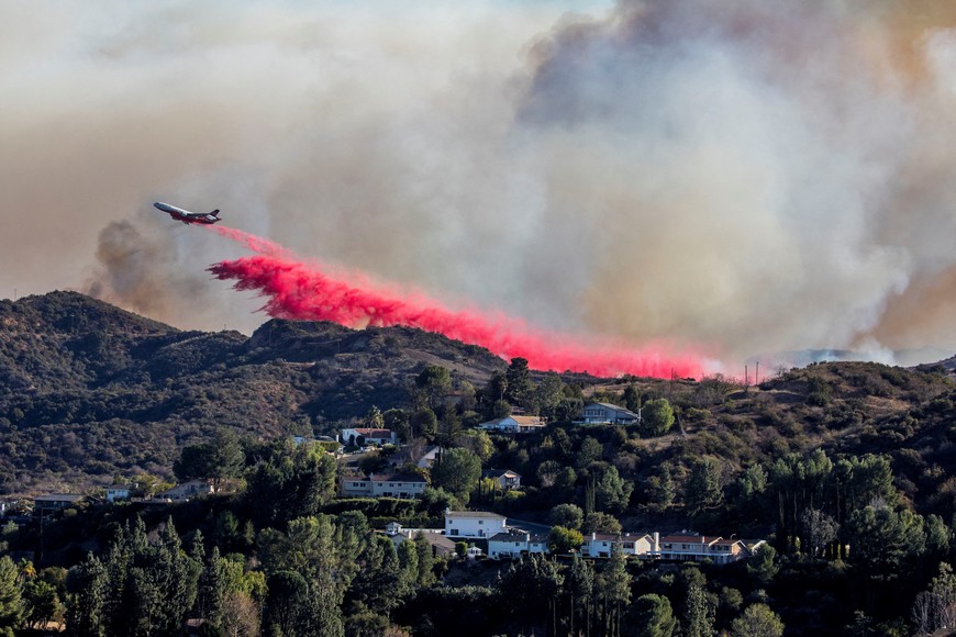 An air tanker drops fire retardant at the Palisades Fire, one of simultaneous blazes that have ripped across Los Angeles County, as seen from Woodland Hills, neighborhood of Los Angeles, California, U.S. January 11, 2025. REUTERS/Ringo Chiu      TPX IMAGES OF THE DAY