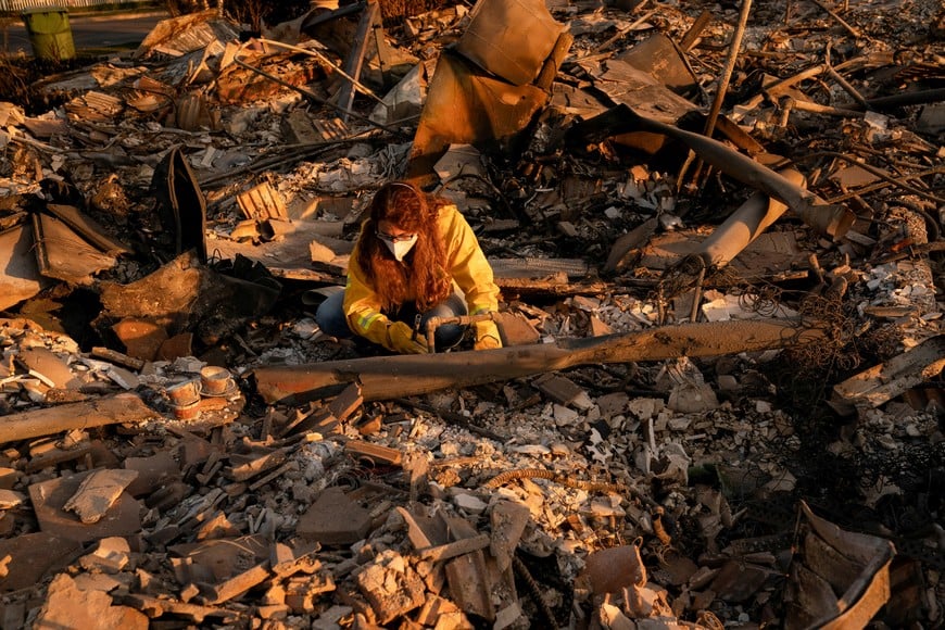 Stacy Weiss looks through the remains of her home, which was destroyed by the Palisades Fire, in the Pacific Palisades neighborhood in Los Angeles, California, U.S. January 11, 2025. REUTERS/David Ryder