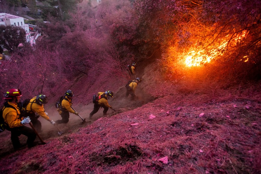 Firefighters work to clear a firebreak as the Palisades Fire, one of several simultaneous blazes that have ripped across Los Angeles County, burns in Mandeville Canyon, a neighborhood of Los Angeles, California, U.S., January 12, 2025. REUTERS/Ringo Chiu