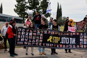 Families and supporters of Israeli hostages kidnapped during the deadly October 7, 2023 attack by Hamas, hold a banner as they gather to demand a deal that will bring back all the hostages held in Gaza, outside a meeting between hostage representatives and Israeli Prime Minister Benjamin Netanyahu, in Jerusalem, January 14, 2025. REUTERS/Ammar Awad