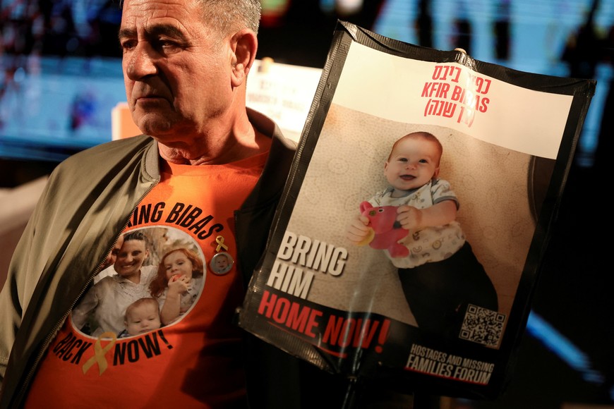 Eli Bibas, grandfather of the youngest hostage in Gaza, Kfir Bibas, who was kidnapped during the deadly October 7 2023 attack by Hamas alongside his mother, Shiri, and brother, Ariel, holds his picture as people gather to mark Kfir's second birthday, before a ceasefire deal between Israel and Hamas is due to go into effect, in Tel Aviv, Israel, January 18, 2025. Kfir's father, Yarden, is also a hostage in Gaza. REUTERS/Nir Elias