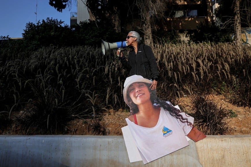 FILE PHOTO: A woman uses a megaphone as she holds a cutout picture of British-Israeli hostage Emily Damari, as demonstrators block the main highway in protest for the return of female hostages held in Gaza since October 7 2023, amid the ongoing conflict between Israel and Hamas, in Tel Aviv, Israel March 14, 2024. REUTERS/Tomer Appelbaum/File Photo ISRAEL OUT. NO COMMERCIAL OR EDITORIAL SALES IN ISRAEL.