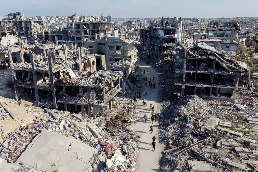 A drone view shows Palestinians walking past the rubble of houses and buildings, following a ceasefire between Israel and Hamas, in Jabalia in the northern Gaza Strip, January 19, 2025. REUTERS/Mahmoud Al-Basos     TPX IMAGES OF THE DAY