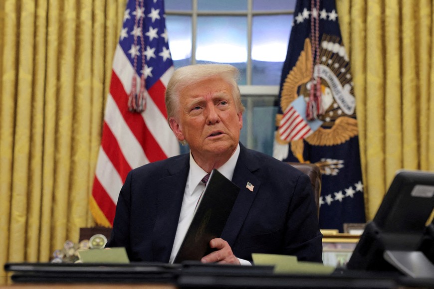 FILE PHOTO: U.S. President Donald Trump signs documents as he issues executive orders and pardons for January 6 defendants in the Oval Office at the White House on Inauguration Day in Washington, U.S., January 20, 2025.  REUTERS/Carlos Barria//File Photo