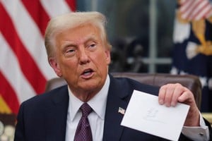 U.S. President Donald Trump holds up a letter from former President Joe Biden as he issues executive orders and pardons for January 6 defendants in the Oval Office at the White House on inauguration day in Washington, U.S., January 20, 2025.  REUTERS/Carlos Barria     TPX IMAGES OF THE DAY