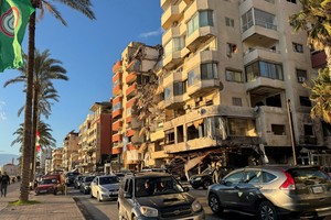 Cars drive past a damaged building near the Corniche, after the Israeli prime minister's office said on Friday that Israeli forces will remain in southern Lebanon beyond a 60-day deadline stipulated in a ceasefire deal with Hezbollah because its terms have not been fully implemented, in Tyre, Lebanon January 24, 2025. REUTERS/Ali Hankir