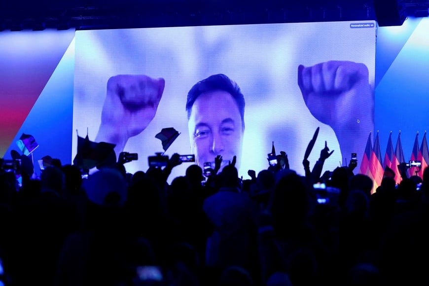 FILE PHOTO: SpaceX CEO Elon Musk gestures as he speaks on-screen during a central election campaign event of the AfD in Halle (Saale), Germany, January 25, 2025.  REUTERS/Karina Hessland/File Photo