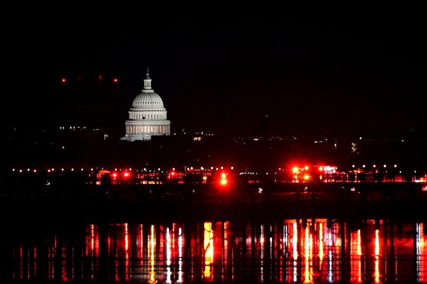 Emergency personnel work near the site of the crash, with the U.S. Capitol in the background, after American Eagle flight 5342 collided with a Black Hawk helicopter while approaching Ronald Reagan Washington National Airport and crashed in the Potomac River, U.S. January 30, 2025. REUTERS/Nathan Howard     TPX IMAGES OF THE DAY