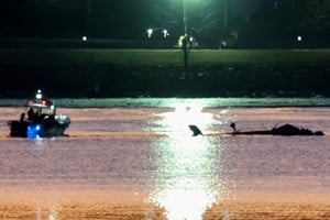 Rescuers on a boat work next to the wreckage of a Black Hawk helicopter at the site of the crash after it collided with the American Eagle flight 5342 which was approaching Reagan Washington National Airport and crashed into the Potomac River, outside Washington, U.S., January 30, 2025. REUTERS/Kevin Lamarque