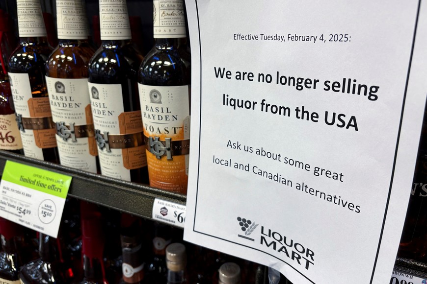 A sign notifying customers that a store will stop selling U.S. liquor from Tuesday, in response to U.S. President Donald Trump's imposition of tariffs on Canada, is displayed on a shelf carrying U.S. alcohol in Winnipeg, Manitoba, Canada, February 2, 2025.   REUTERS/Ed White