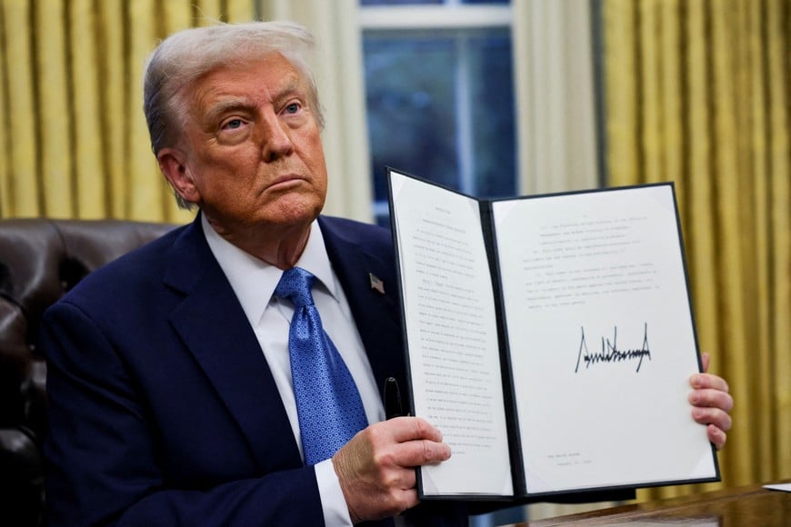 FILE PHOTO: U.S. President Donald Trump holds a signed executive order in the Oval Office at the White House in Washington, U.S., January 31, 2025. REUTERS/Carlos Barria/File Photo