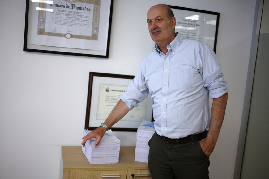 Argentina's Deregulation and State Transformation Minister Federico Sturzenegger poses next to a package of reforms and new laws known as the "omnibus bill", during an interview with Reuters, in Buenos Aires, Argentina January 28, 2025. REUTERS/Agustin Marcarian