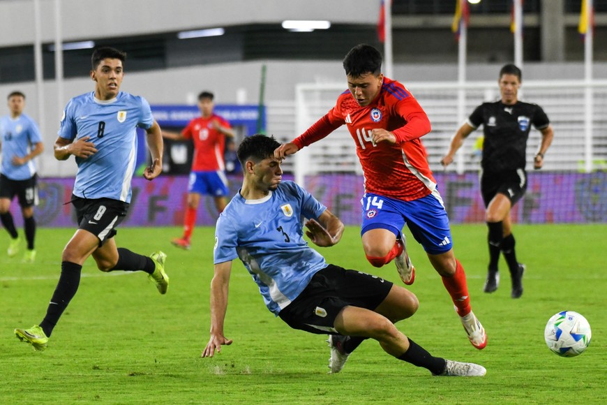 (250211) -- CARACAS, 11 febrero, 2025 (Xinhua) -- Imagen del 10 de febrero de 2025 del jugador Ignacio Vásquez (d), de Chile, disputando el balón con Paolo Calione (i-abajo) de Uruguay, durante el partido correspondiente a la tercera fecha de la fase final del torneo Sudamericano Sub-20 de la Confederación Sudamericana de Fútbol (Conmebol) celebrado en el Estadio Olímpico Nacional Brígido Iriarte, en Caracas, Venezuela. (Xinhua/Marcos Salgado) (ms) (oa) (ah) (vf)