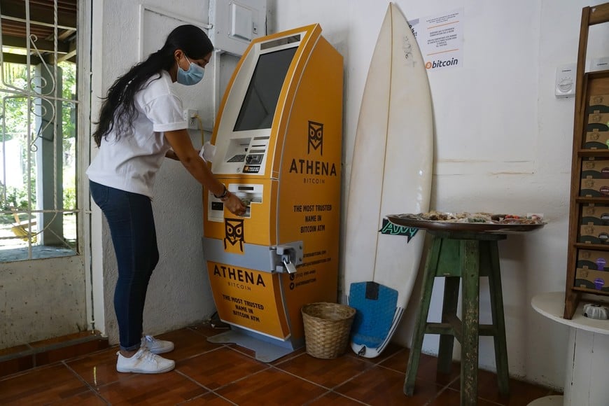 (210610) -- LA LIBERTAD, 10 junio, 2021 (Xinhua) -- Imagen del 7 de junio de 2021 de una mujer retirando efectivo en un cajero de Bitcoin, en la comunidad costera de El Zonte, en el departamento de La Libertad, El Salvador. El Salvador se convirtió el 9 de junio en el primer país del mundo en aprobar al Bitcoin como moneda de curso legal, luego de que el Congreso respaldó una propuesta del presidente Nayib Bukele para hacerlo. (Xinhua/Alexander Peña) (ap) (ah) (da) (vf)