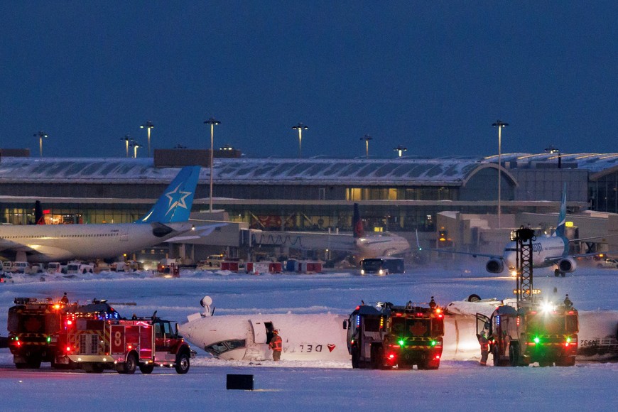 Emergency responders operate around a plane on a runway after a plane crash at Toronto Pearson International Airport in Mississauga, Ontario, Canada February 17, 2025. REUTERS/Cole Burston