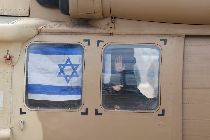 Tal Shoham, a hostage held in Gaza since the deadly October 7, 2023 attack, waves from a helicopter on the day of the release of hostages who were released from captivity in Gaza as part of hostages-prisoners swap and a ceasefire deal between Hamas and Israel, in Reim, Israel February 22, 2025. REUTERS/Amir Cohen     TPX IMAGES OF THE DAY