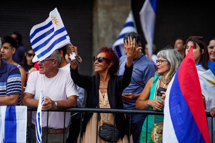 People hold flags as they gather near the Legislative Palace to attend the swearing-in ceremony of Uruguay's President-elect Yamandu Orsi, in Montevideo, Uruguay March 1, 2025. REUTERS/Andres Cuenca