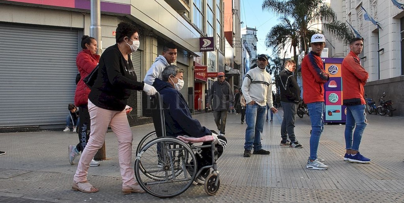 Las fotos del día 15 de cuarentena: filas en los bancos, vacunación y entrega de alimentos